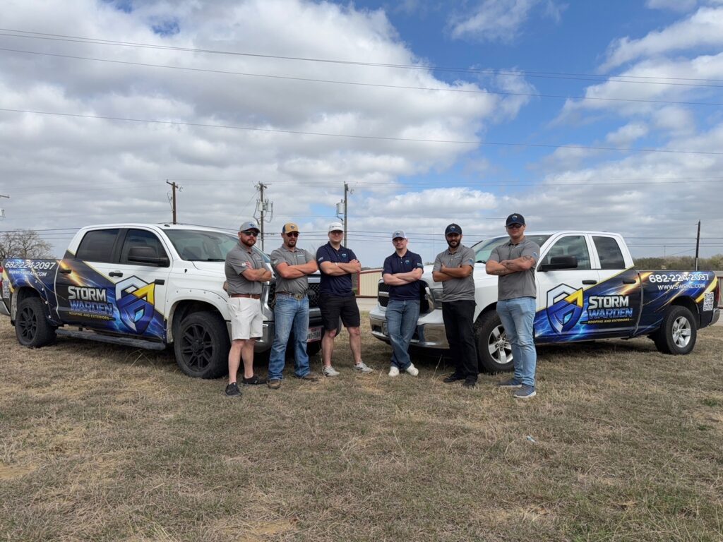 Team at Storm Warden standing in front of two company trucks
